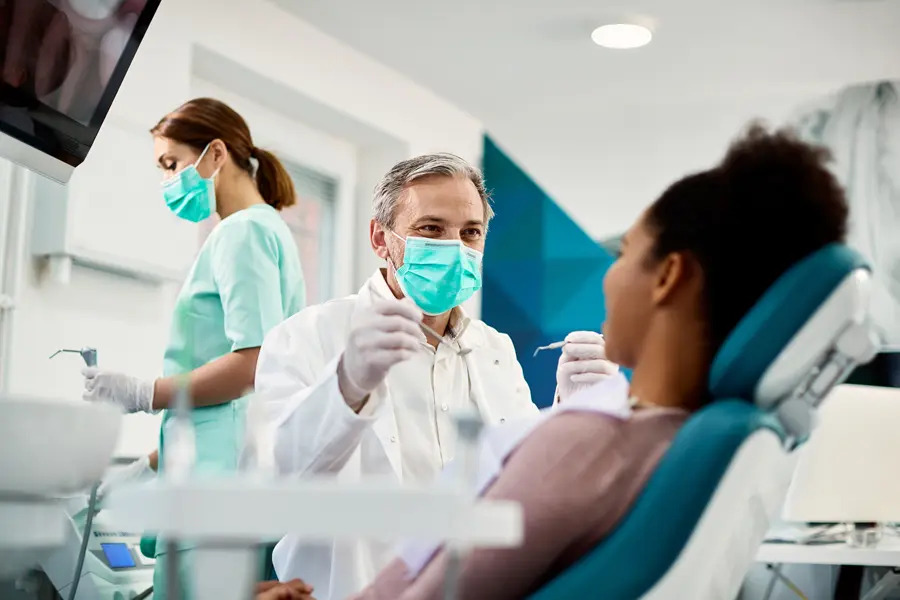 A friendly dentist and assistant providing attentive care to a patient, ensuring a comfortable and reassuring experience. Their patient-first approach fosters trust and confidence, highlighting a commitment to personalised dental treatments in a welcoming and professional environment.