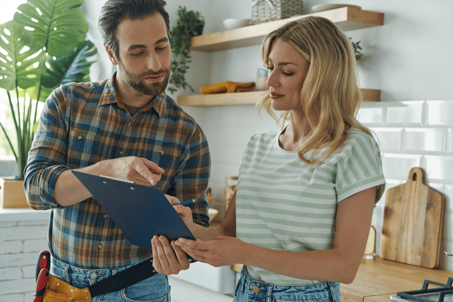 A professional plumber discusses details with a satisfied customer in a bright, modern kitchen. The image highlights clear communication, trust, and customer satisfaction, emphasising the importance of reliable service and transparency in plumbing repairs and maintenance.